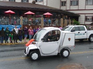 The Park's small two-seat electric vehicle driving down the road during a parade.