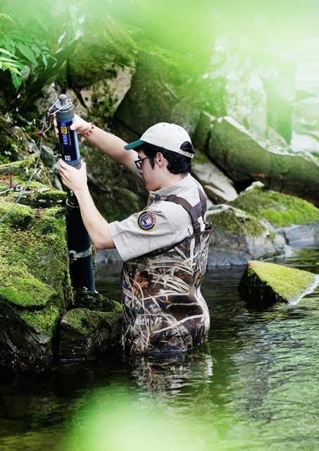 Man Standing in the River Using Measuring Device Man Standing in the River Using Measuring Device