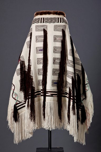 Photo of the black and white, textile DNA Robe, which was woven by Teri Rofkar, on a display stand