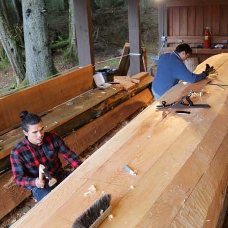 Artists TJ Young and Jerrod Galanin work on the underside of the canoe. Artists TJ Young and Jerrod Galanin work on the underside of the canoe.