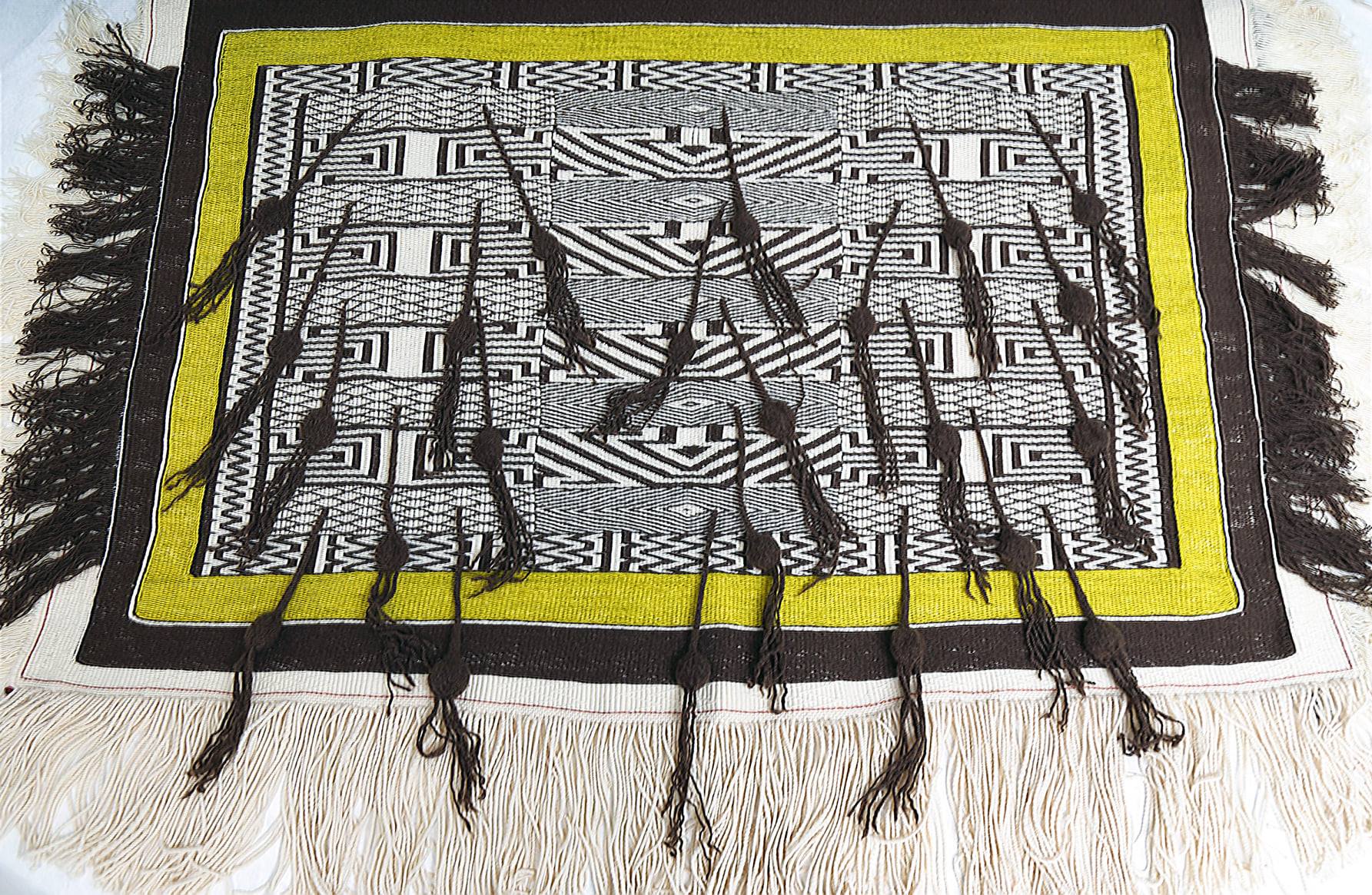 Ravens Tail Centennial Robe A woven textile in brown, white, and yellow with white and brown tassels and fringe