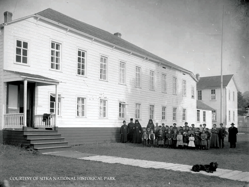 SITK 26316 Adults and children with Bishop Innocent outside the Russian Bishop's House Long two-story building with a group of priests and children on a lawn