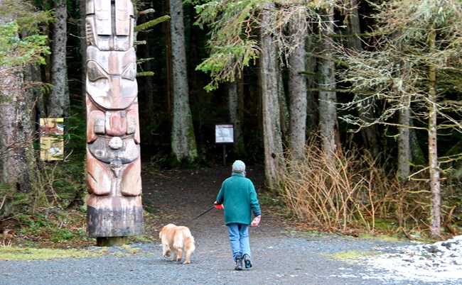 Woman walking dog on park trail