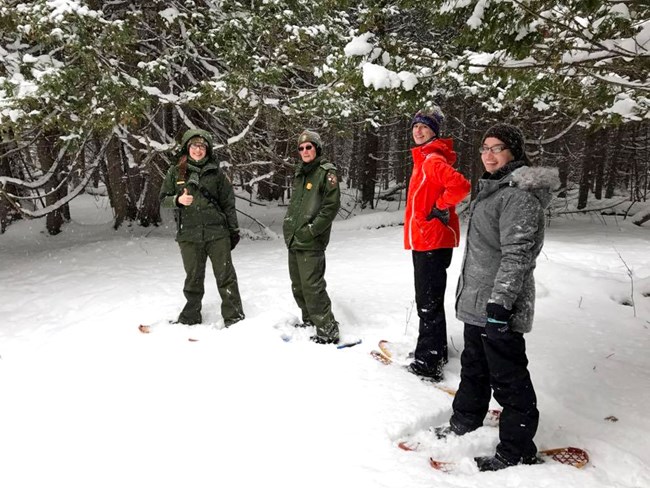 Two rangers and two interns on snowshoes