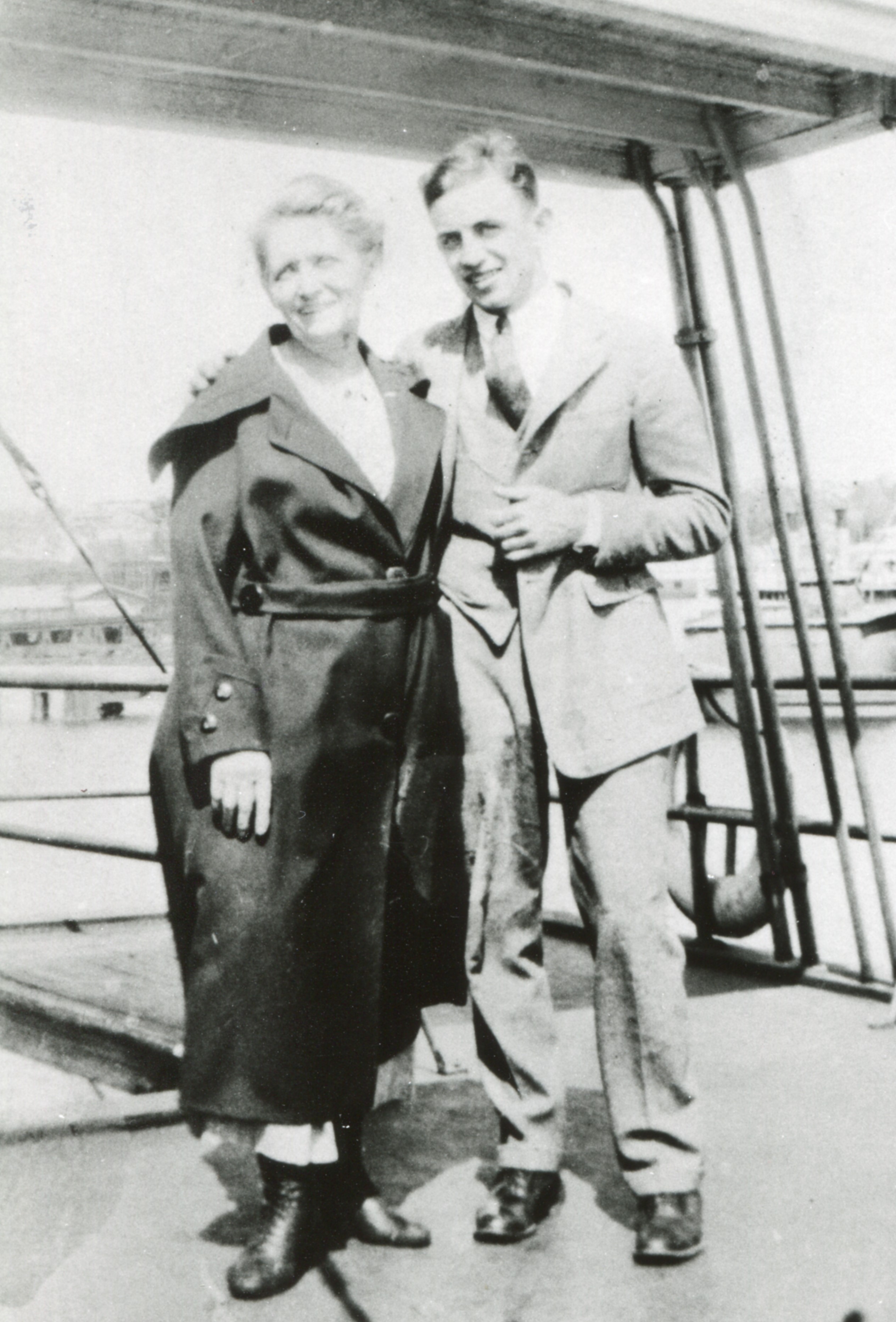 A black and white image of two people standing together and smiling.