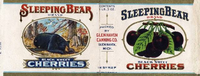 Label for canned cherries, with illustrations of a sleeping bear and cherries. Text says "Sleeping Bear brand Black Sweet Cherries, packed by Glen Haven Canning Co."