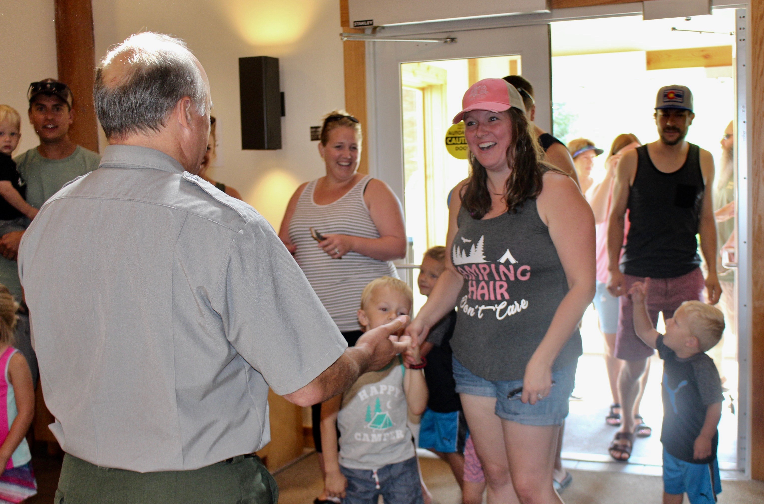 50 millionth visitor and her two young children at greeted at the door by deputy superintendent