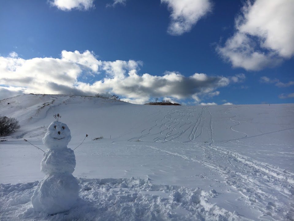 Snowman at base of snow-covered Dune Climb