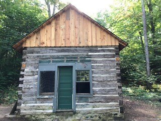 Log cabin with new wood in peak