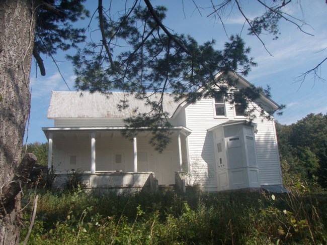 White house with bay window and covered porch