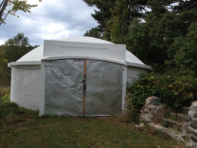 Round outbuilding made of concrete with domed roof and two metal doors