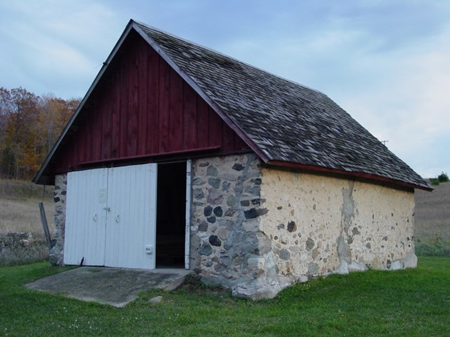 Stone outbuilding with red-painted peak