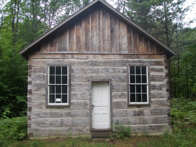 Log building with two windows on either side of a door