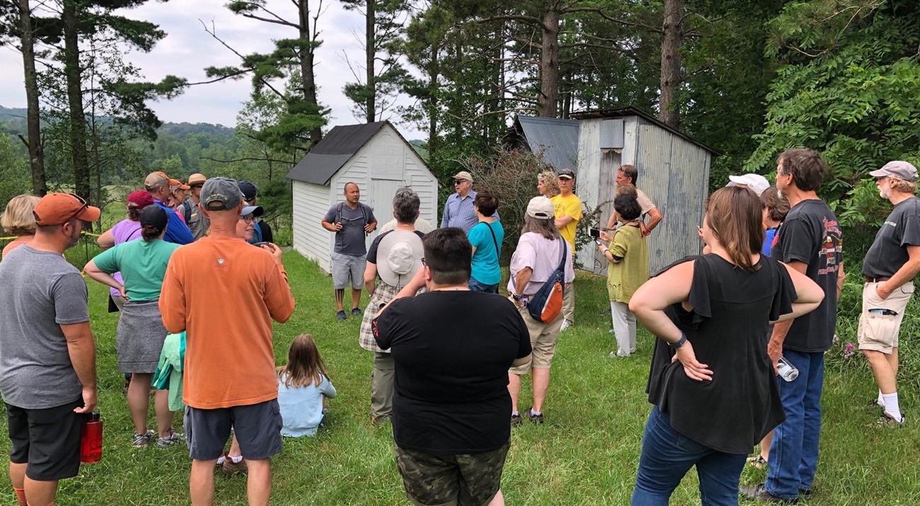 A group of hikers listening to Eric Heminway at the Treat Farm