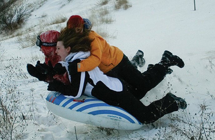 Sledding down the Dune Climb