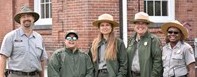 Join Us! Five people dressed in National Park Service uniforms, standing in a row and smiling. .