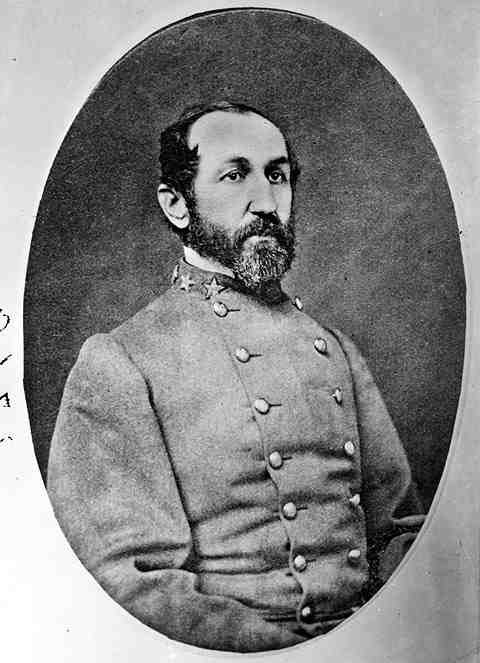 A black and white portrait of a bearded man wearing a buttoned coat.