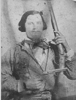 A black and white portrait of a Civil War Soldier holding tow firearms.