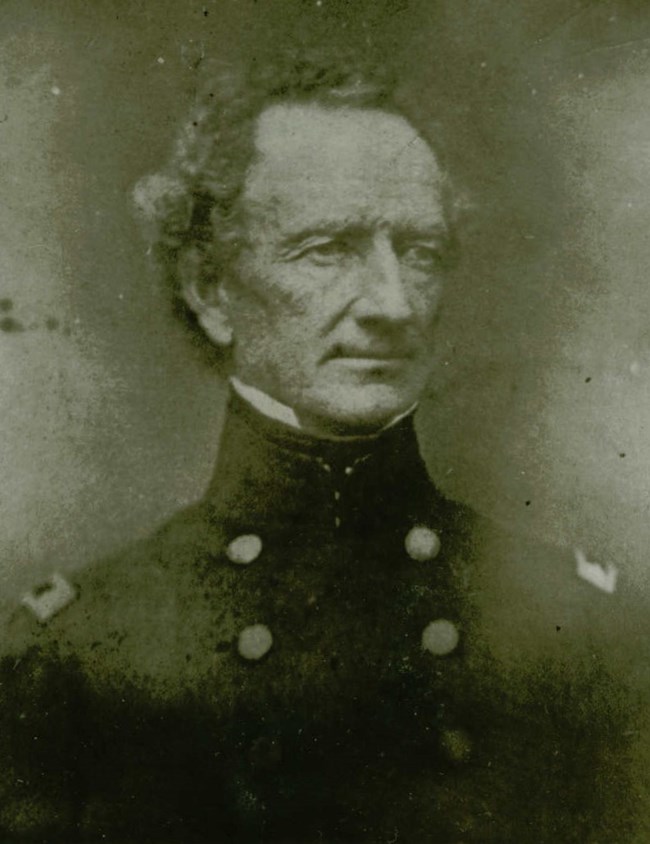 A black and white portrait of a man in uniform.