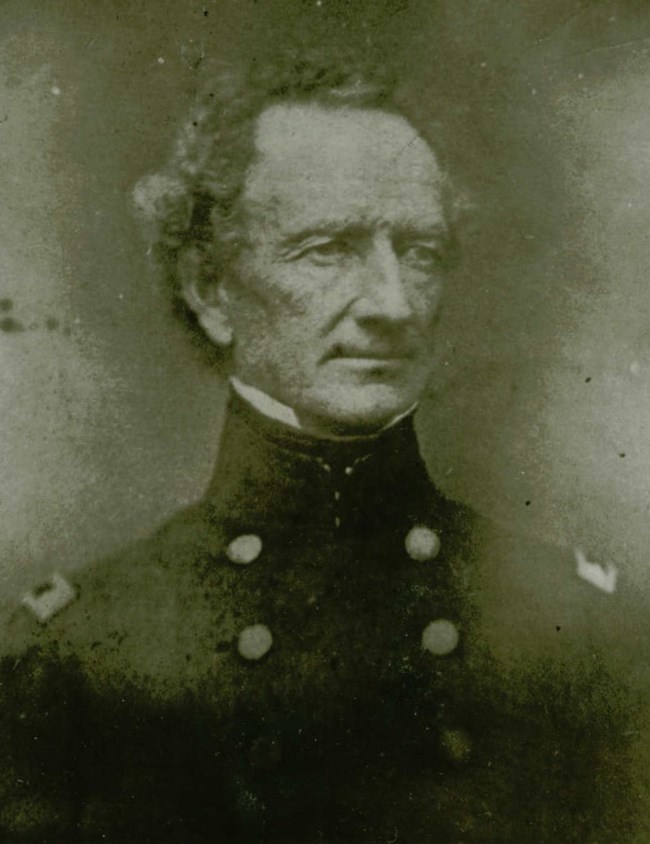 A black and white portrait of a man in uniform.
