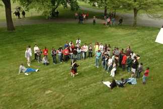 SPAR event with a group of people standing and sitting on an open grassy field