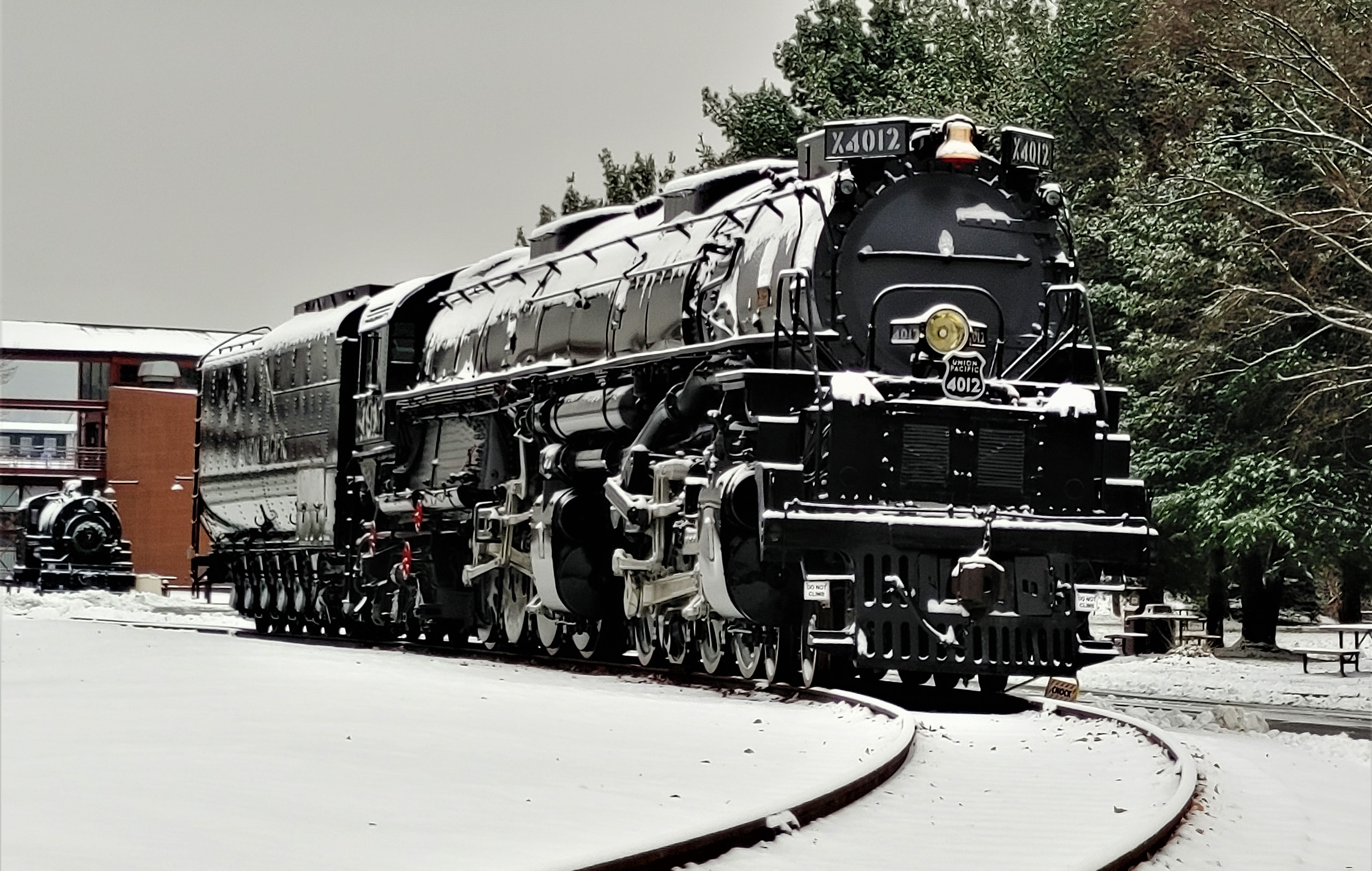 The Union Pacific "Big Boy" No. 4012 covered in a dusting of snow Exterior photo of a large black steam locomotive covered in a dusting of snow