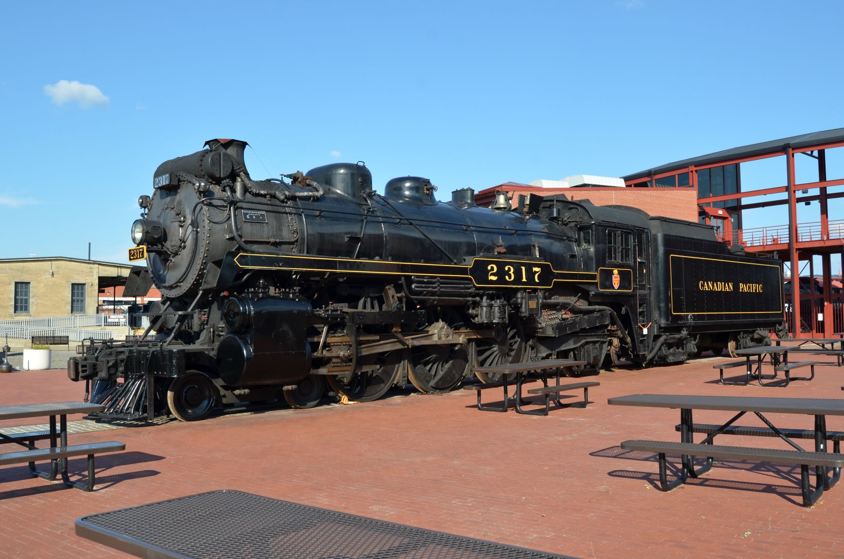 Steam locomotive displayed among picnic tables