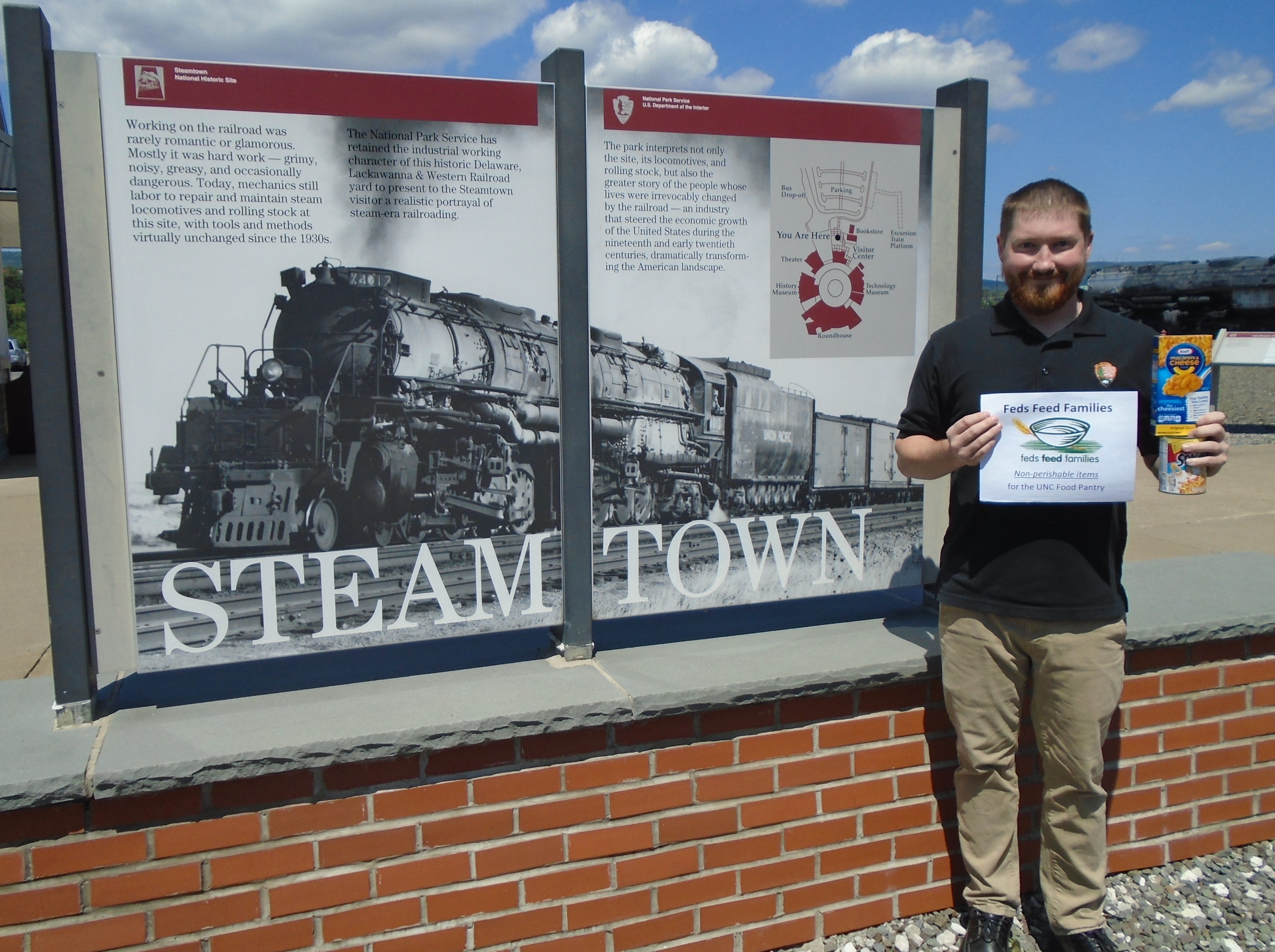 Fed Feed Families - Sweetwood photo of steamtown employee promoting "Fees Feed Families"