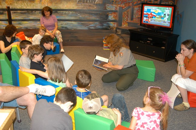 Park ranger assists children learning about steam-era railroad workers