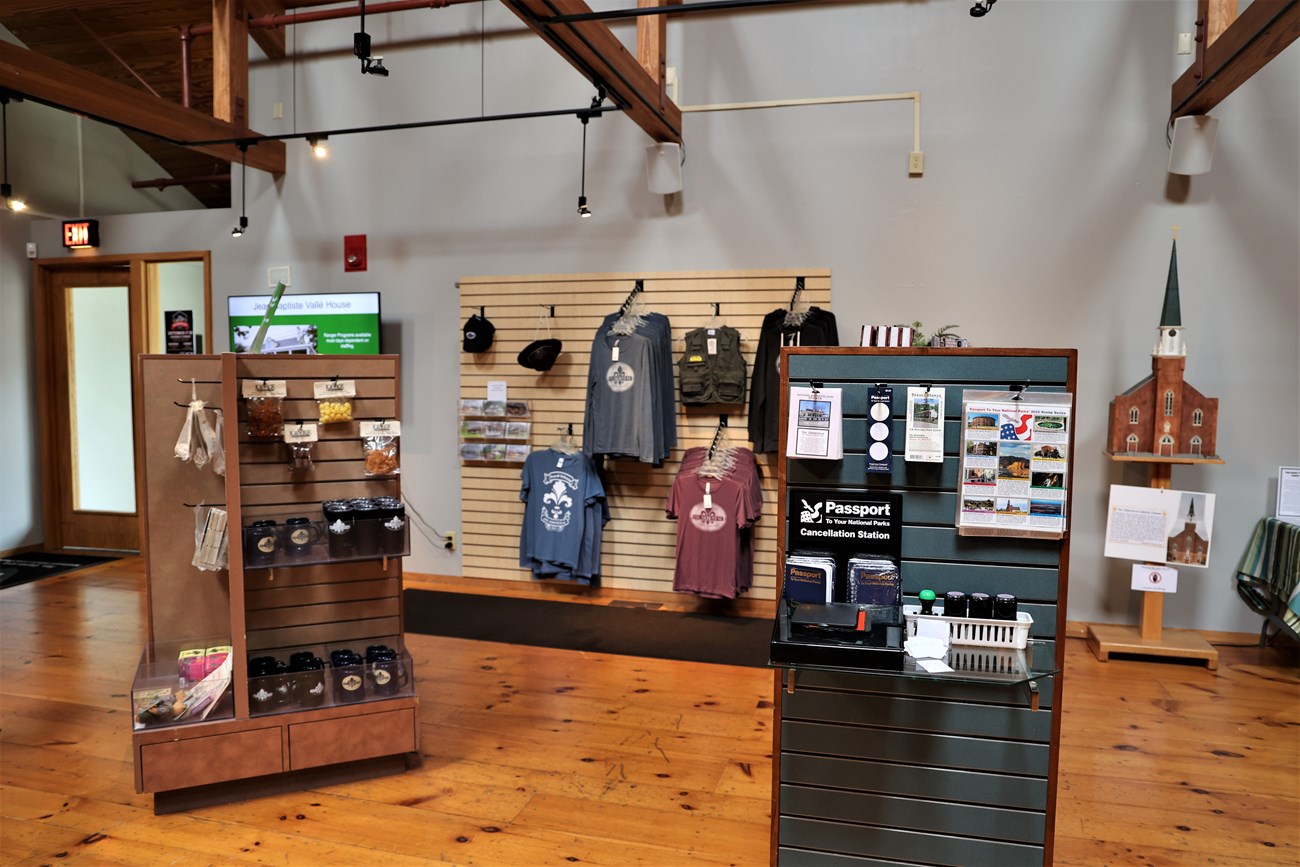 Small store with two standing displays and one against a back wall.