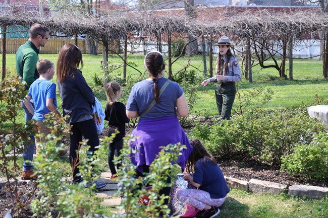 Ranger talks with visitors in rose garden