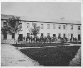 A photograph of soldiers in front of the Garrison's Quarters on Bedloe's Island in 1864.