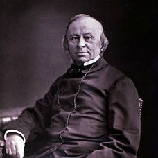 A black and white photograph of a seated older gentleman with a dark jacket and high collar.