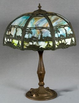 A souvenir lamp. The lampshade depicts the Statue of Liberty alongside buildings, boats, and trees.