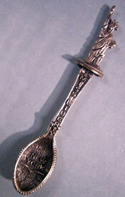 A souvenir spoon with a likeness of the Statue of Liberty.