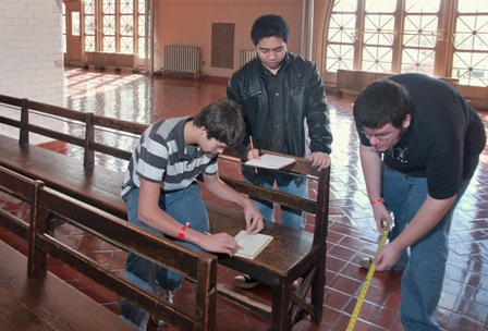 Students take careful measurements of historic benches at Ellis Island.