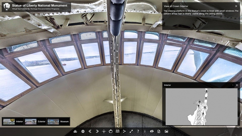 Virtual Tour Interface including view from inside Statue of Liberty crown: row of small windows looking out to NY Harbor surrounded by beige-painted interior of statue.