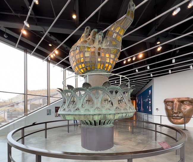 The original torch of the Statue of Liberty in the museum with a replica of the Statue's face.