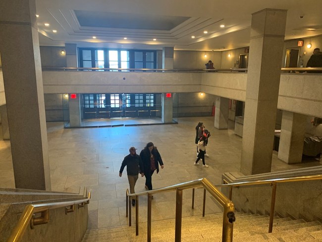 Looking down a flight of stairs towards the lobby and entrance doors