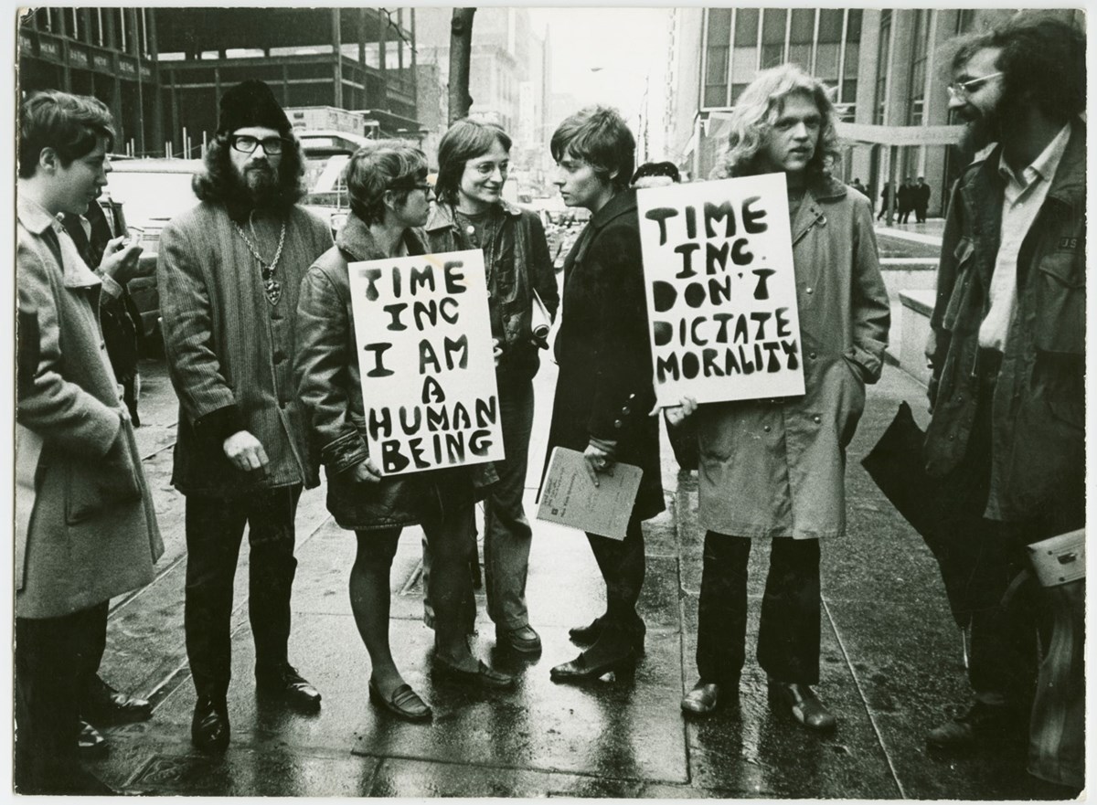 People protesting with signs reading 'Time Inc. I am a human being'