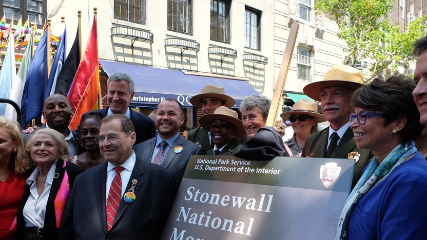 Many people around a sign that reads 'Stonewall National Monument'