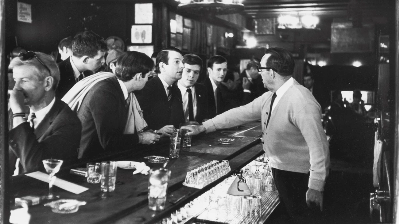 Mattachine Society 'Sip-In,' 1966 Bartender at Julius's Bar refusing drinks to four men in suits in a crowded bar
