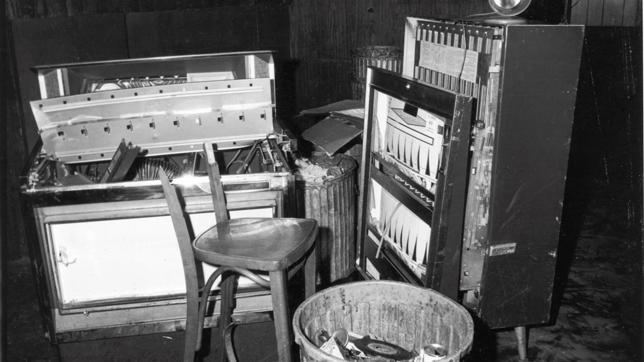 Inside the Stonewall Inn After Riots, 1969 View of a damaged jukebox, cigarette machine, broken chair, and trash can inside of the Stonewall Inn