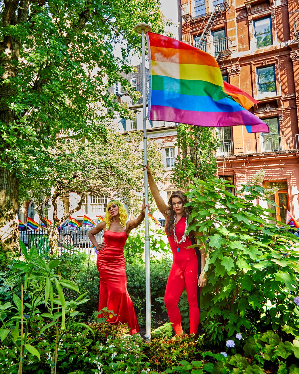 Portraits of Miss Simone and Monet at Stonewall National Monument, Miss Simone and Monet posing by a rainbow flag in a garden