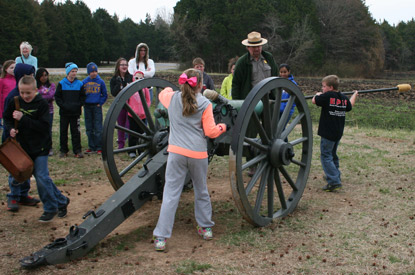 Kids learn to load and fire a cannon with help from a ranger. Kids learn to load and fire a cannon with help from a ranger.