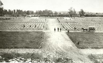 1865 photo of Stones River National Cemetery shows fresh graves and workers.