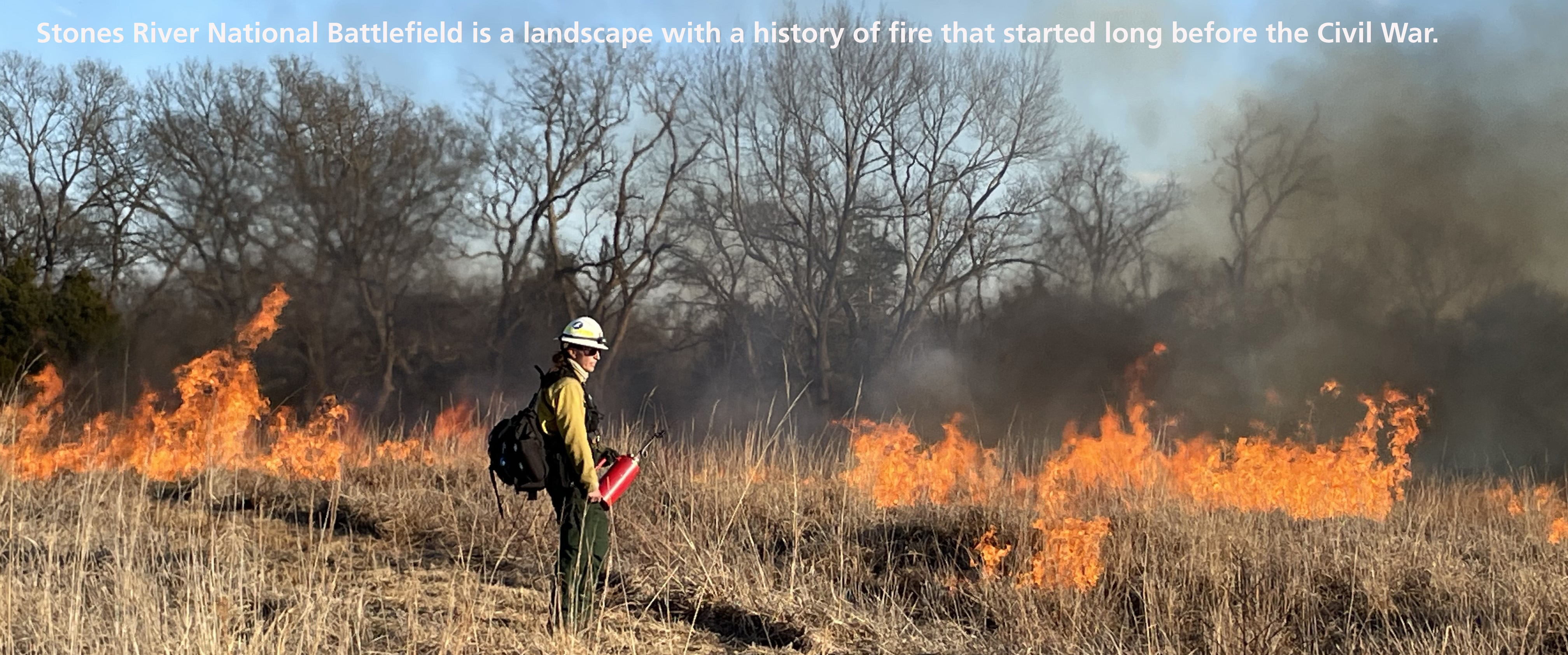 a person in protective fire equipment observing a prescribed fire