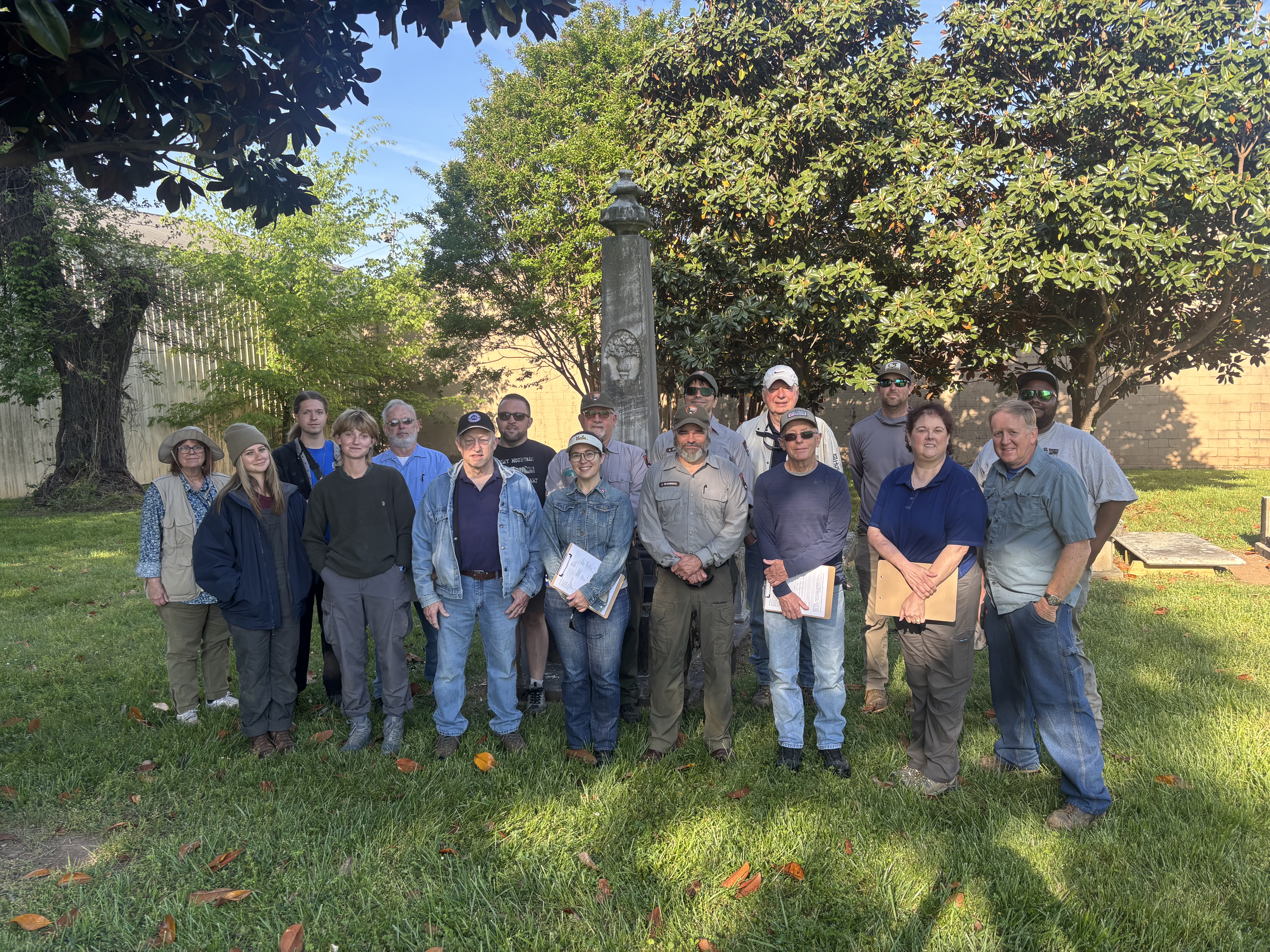 People stand in front of an obelisk monument.