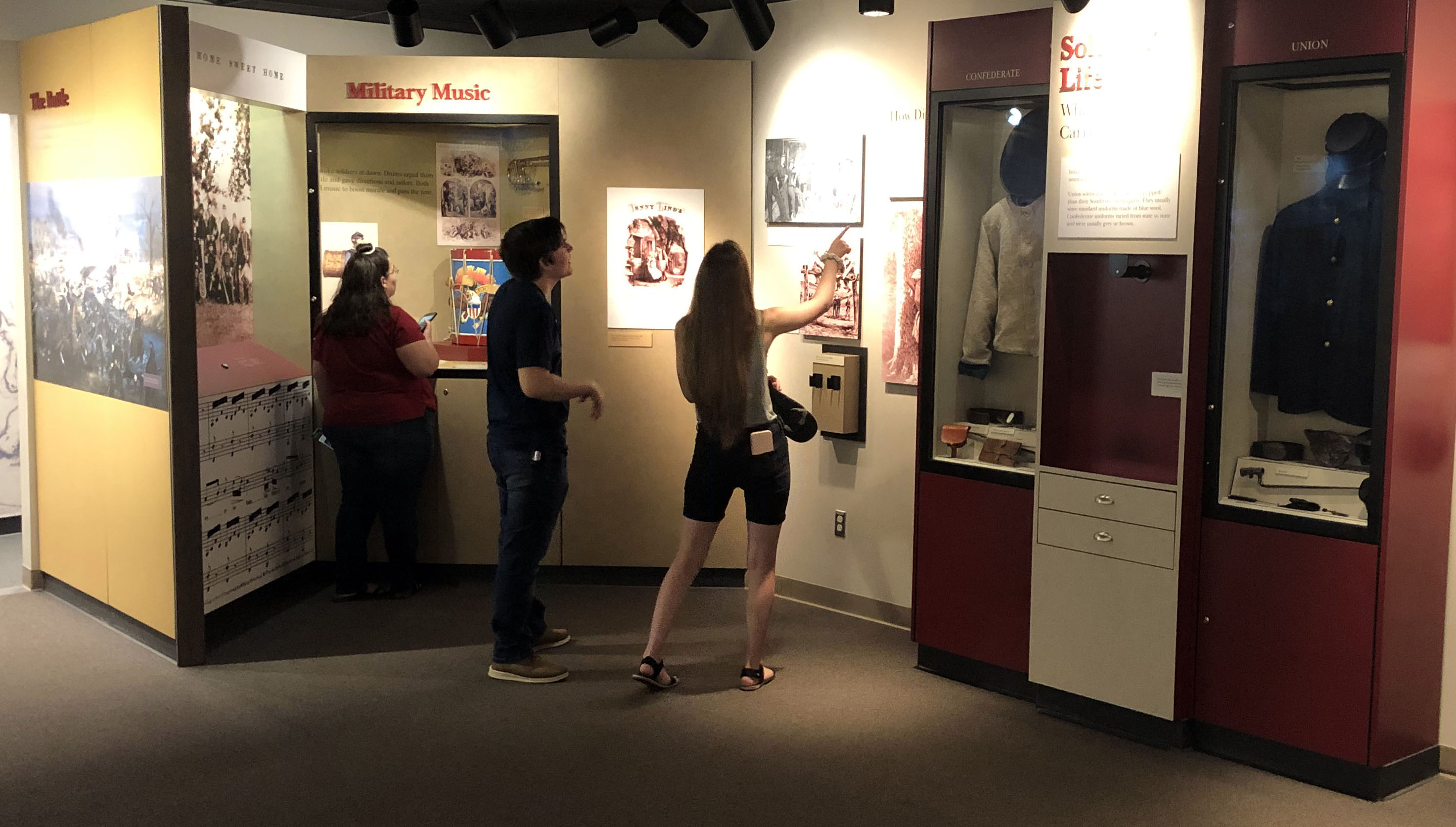 NPS Photo Two women and one man look at museum exhibits.