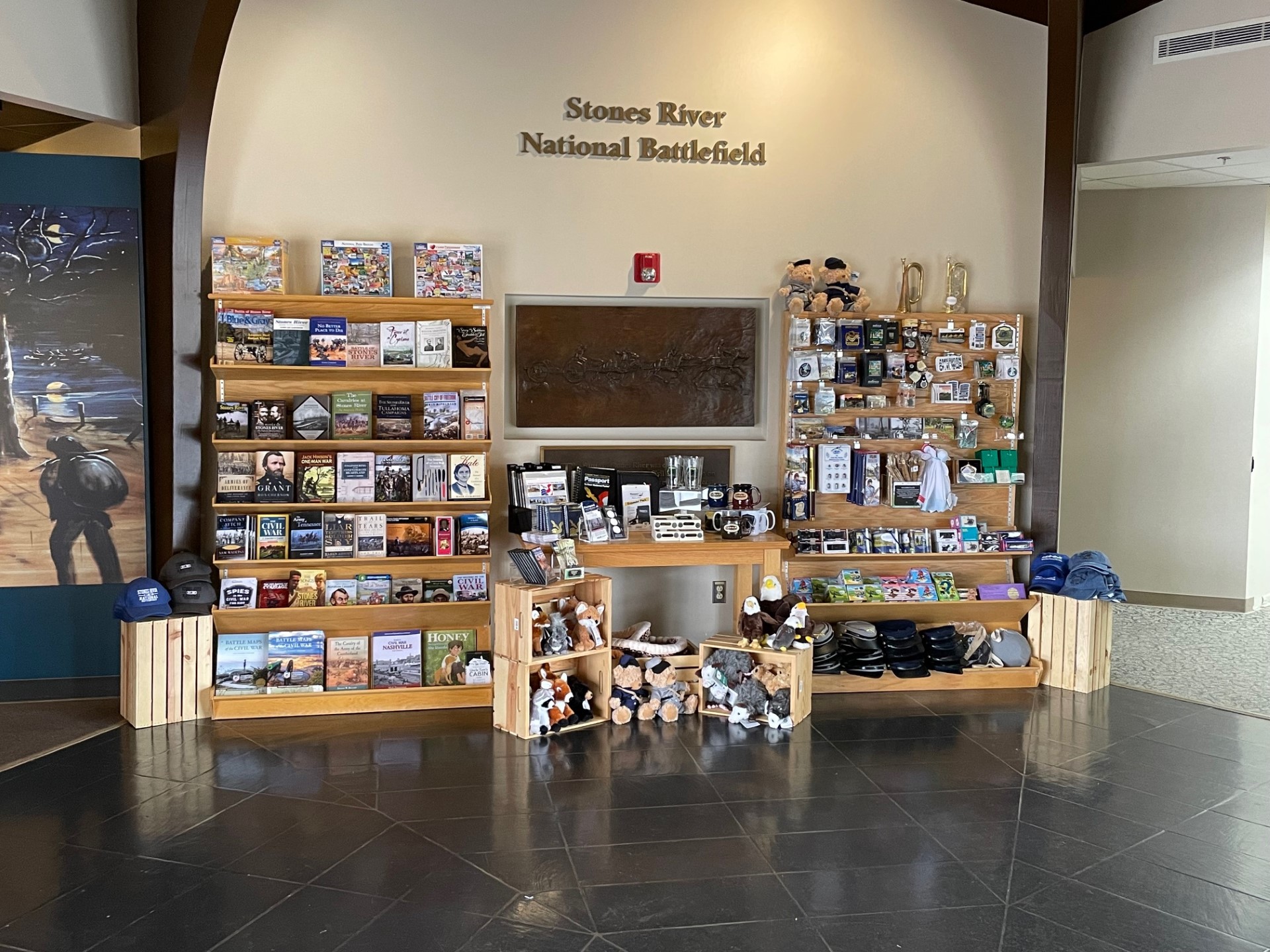 STORE Two shelf units holding books and souvenir items stand on either side of a table covered with books and boxes